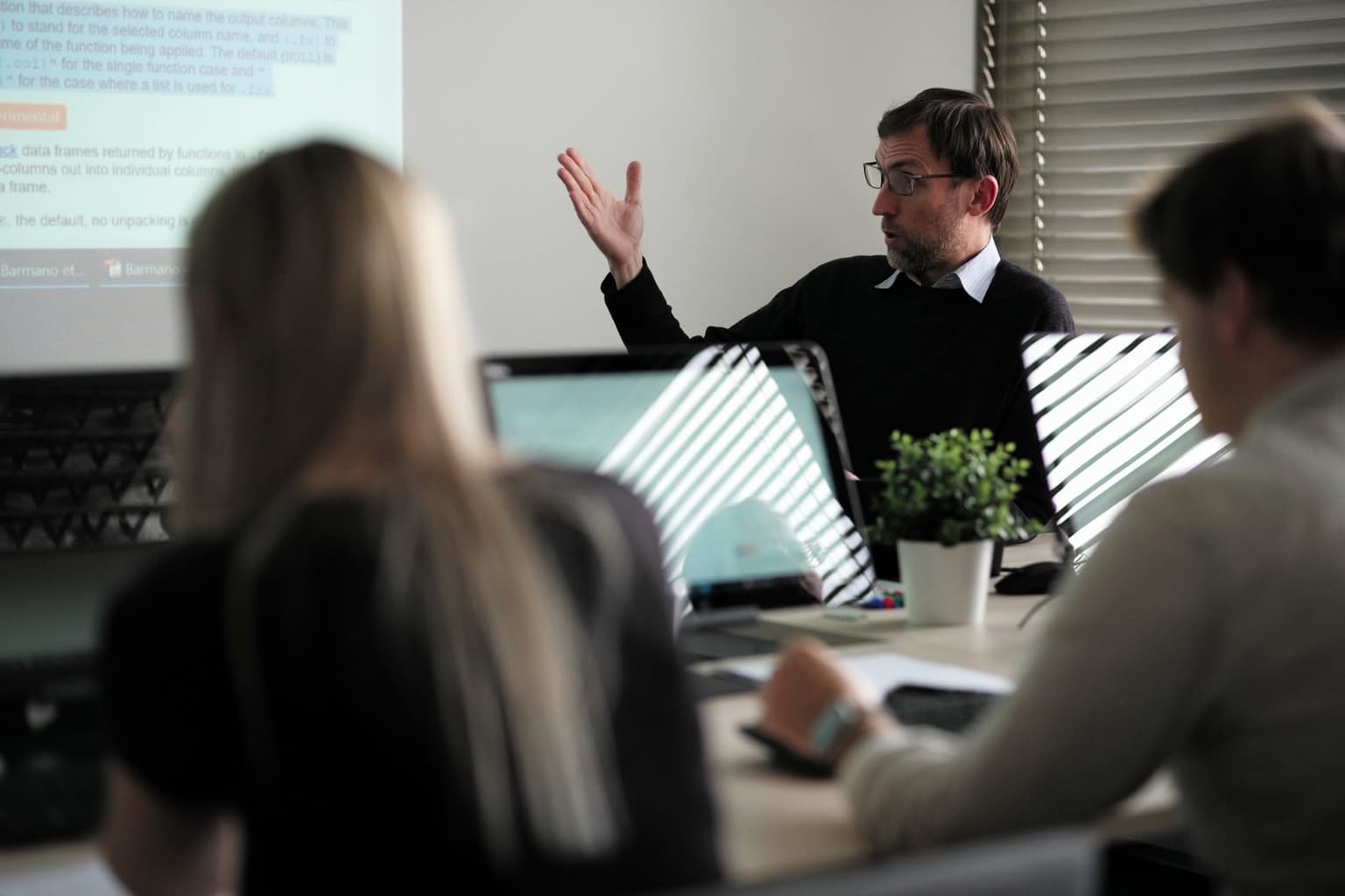 Lektor vysvětluje postup u projekce, účastníci školení sledují od svých počítačů