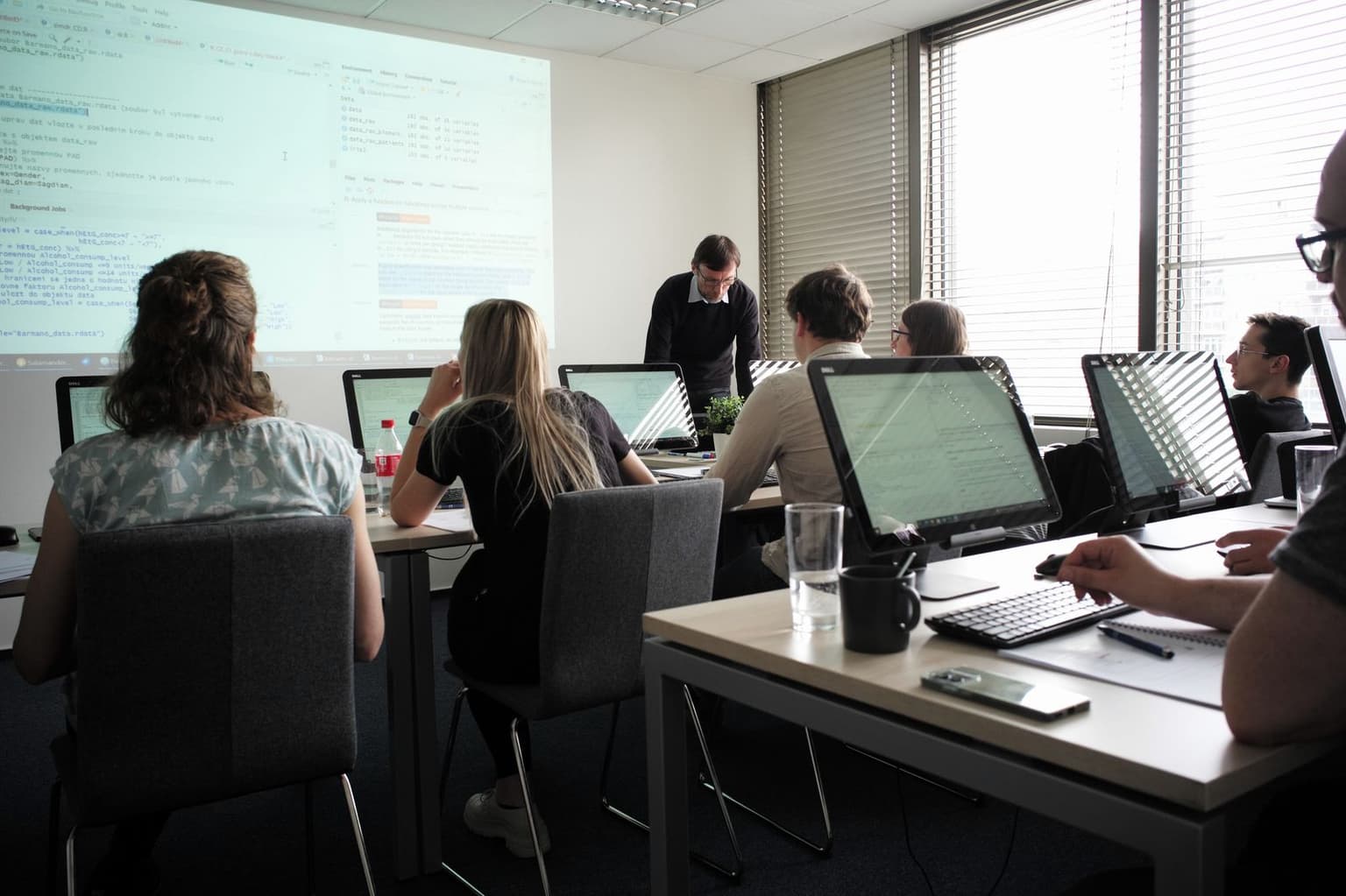 Učebna 4D Center při výkladu – projektor, lektor vpředu, účastníci u monitorů